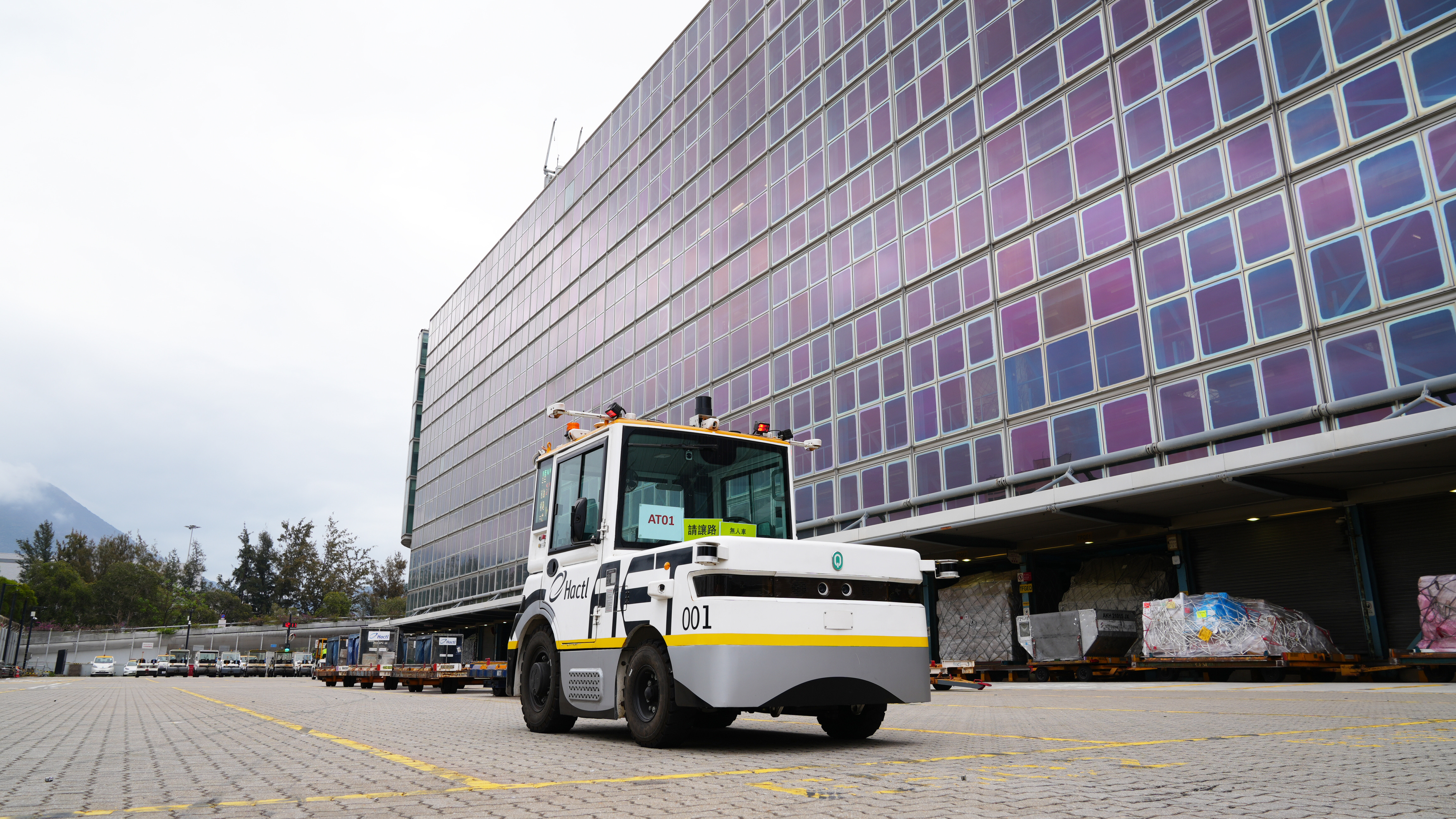 Westwell Q-Tractor autonomous Level 4 tow tractor operating at Hong Kong Air Cargo Terminals Limited (Hactl), demonstrating smart airport cargo handling automation.