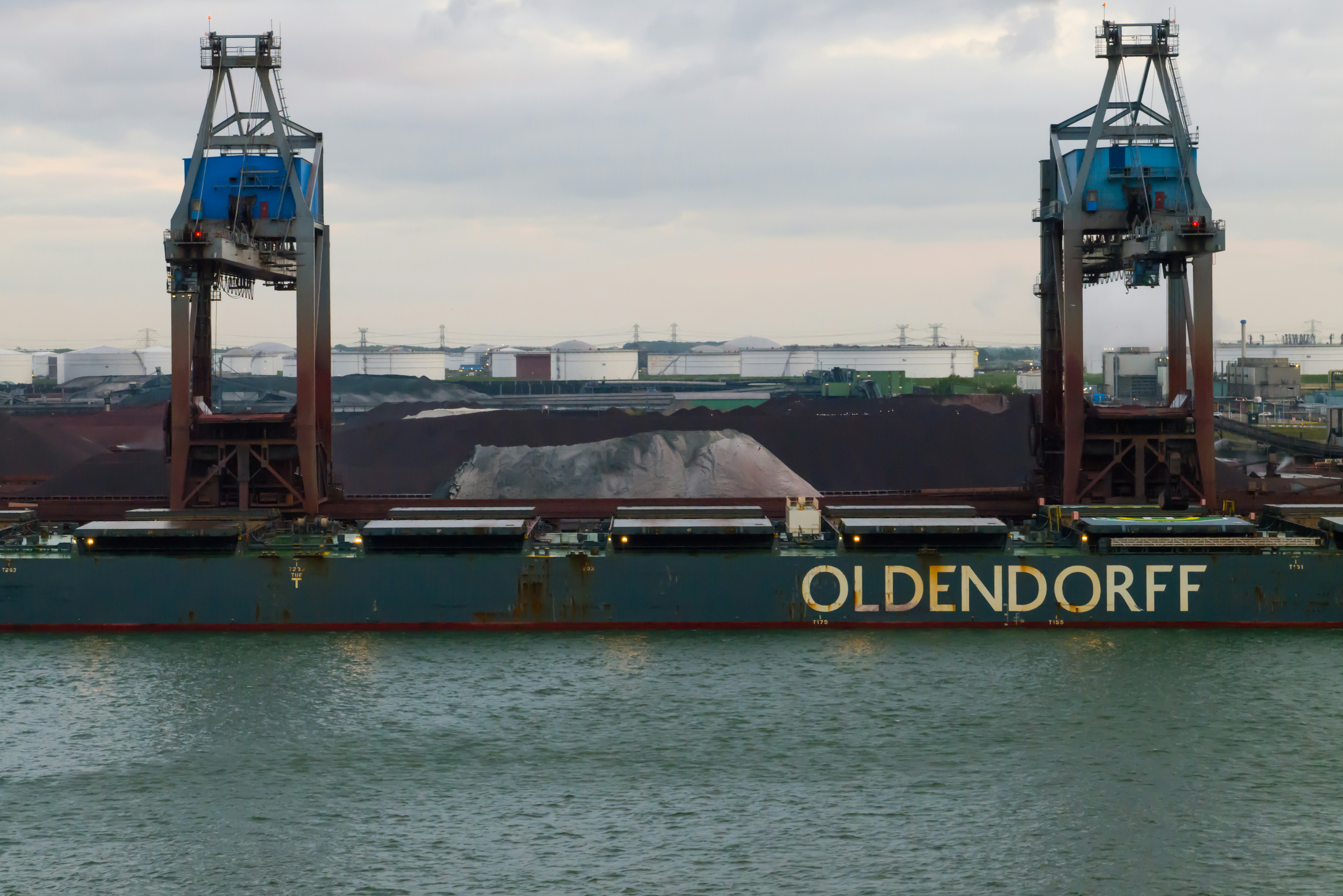 Bulk cargo terminal with ship loaders transferring dry bulk materials onto a cargo vessel, illustrating large-scale bulk material handling at a modern seaport.