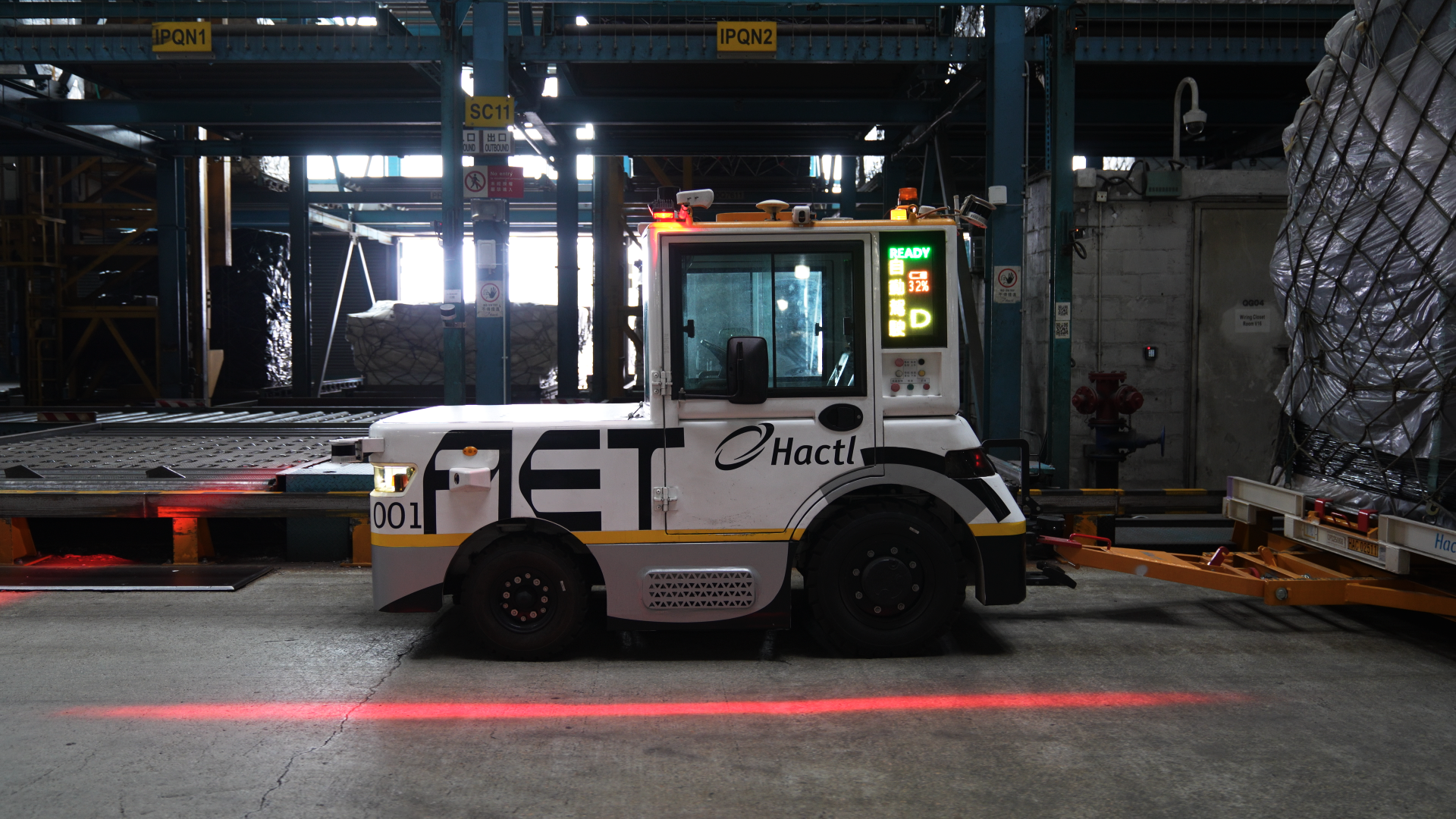Westwell Q-Tractor P40 autonomous electric tow tractor moving cargo dollies inside Hactl&rsquo;s Hong Kong air cargo terminal
