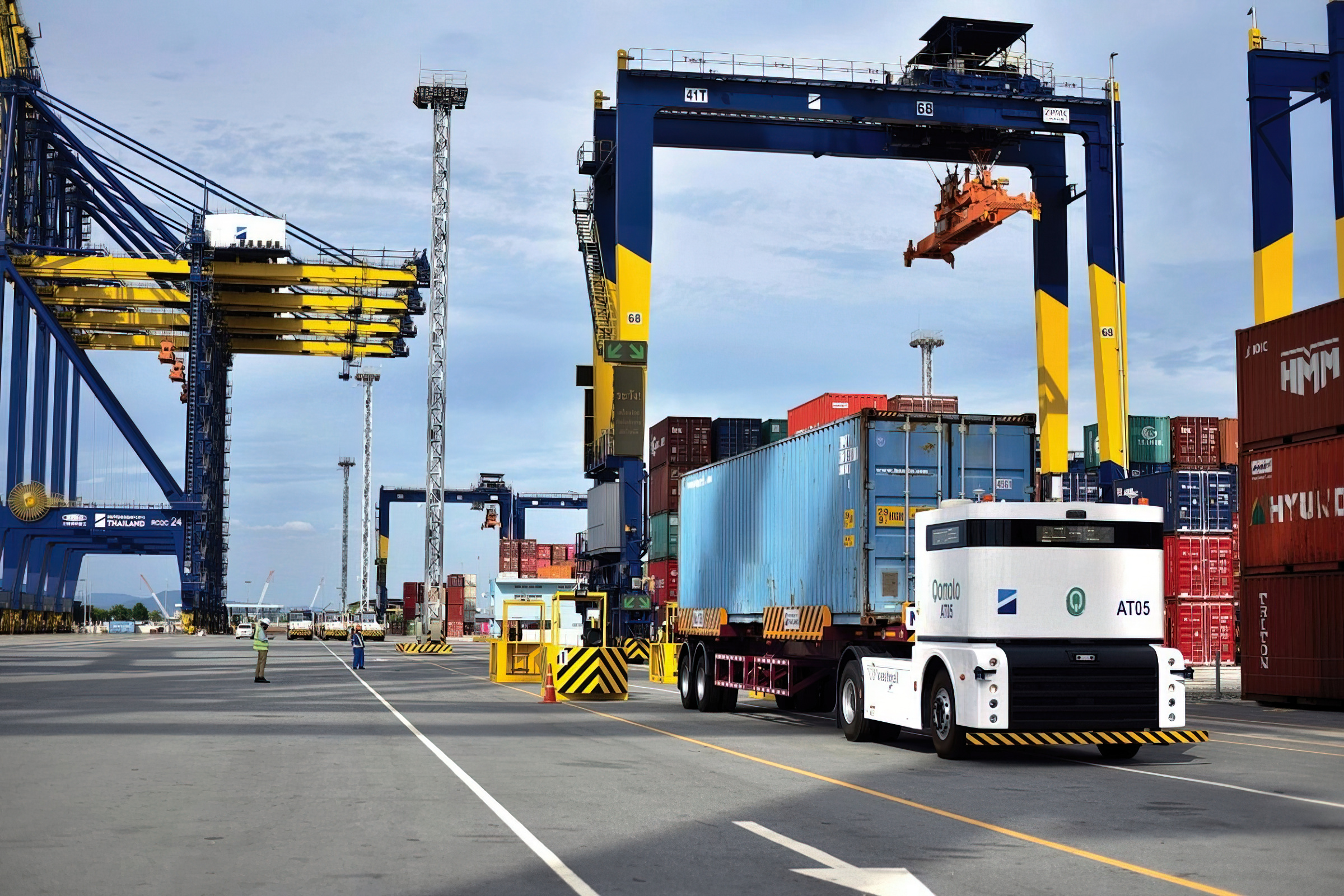 Westwell autonomous terminal tractor positioned beneath a yard gantry crane during container handling in a seaport container yard.